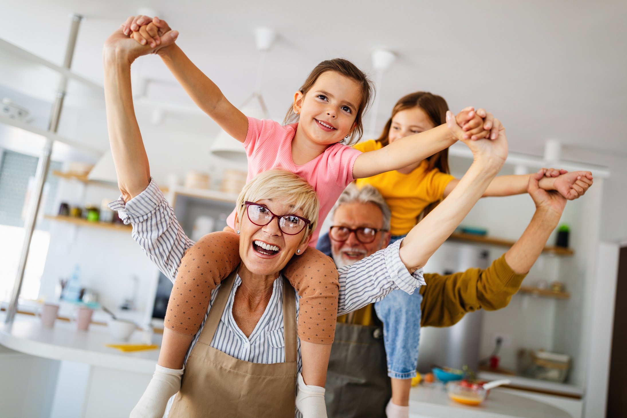 Happy grandparents having fun times with children at home